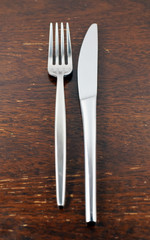 Stylish steel cutlery on a vintage wooden table