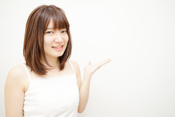Young woman pointing something with white background