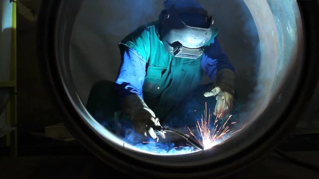 Welder inside Pipe, Welding the Seam to Create One Continuous Section of Pipe. 