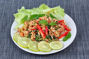 Thai food,Fried spicy basil with minced pork topped sliced green lemon and and lettuce .