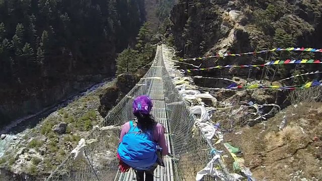 Rear view of woman walking along the suspension bridge,slow motion, high speed camera