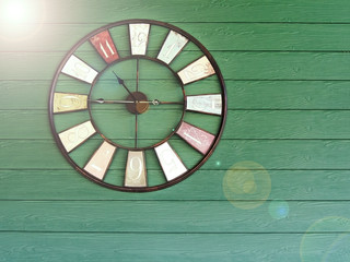 Old vintage with flare clock on green wooden plank wall background. Time management concept.