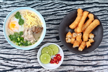 Rice porridge with mined pork and chicken lever served with side dish as Patongko (deep-fried dough stick) and spicy sour filling.