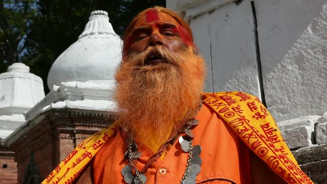 Portrait of Holy Sadhu man with long beard and traditional face paint in Pashupatinath Temple, Kathamandu, Nepal.