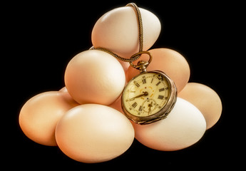 Eggs time - an old pocket watch on a pile of eggs