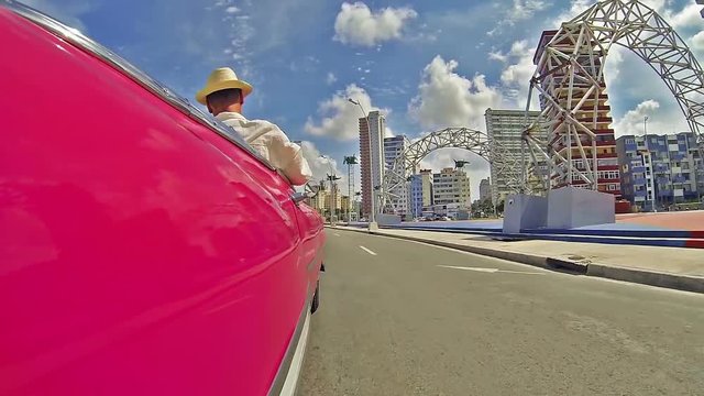  Driving through Havana streets , Cuba.Urban scene, traffic, subjective view, camera fixed at the car .Man photographing from car city scape
