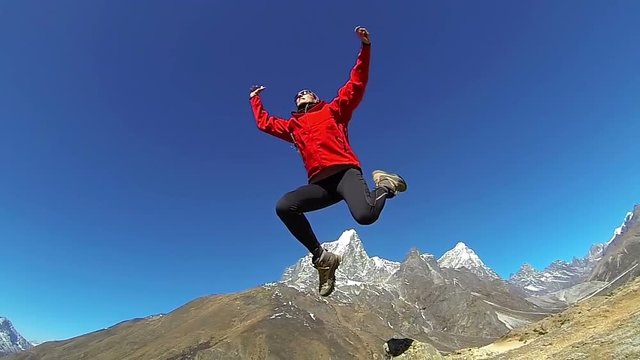 Female mountaineer jumping on the top of world, Mount Everest,Himalayas .Slow motion, high speed camera
