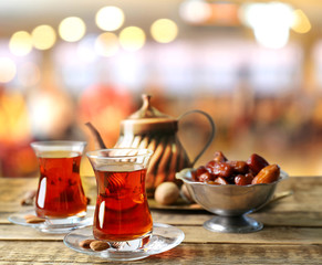 Composition for Turkish tea ceremony on wooden table against blurred interior background. Culture heritage concept.