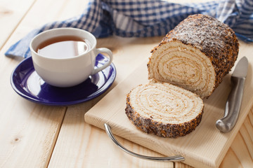 swiss roll and tea on a table, selective focus