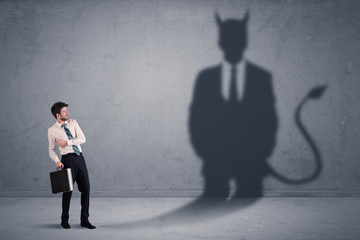Fototapeta premium Business man looking at his own devil demon shadow concept