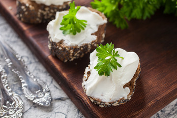sandwiches from rye bread with cheese and parsley on a table, selective focus