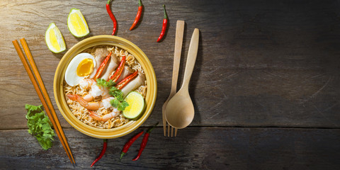 Thai food style noodle, tom yum kung on wood background 