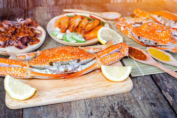 Delicious grilled seafood (jumbo crabs, prawns,  squids) with spices on wood table