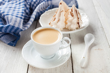 coffee and cakes of meringue on a table, selective focus