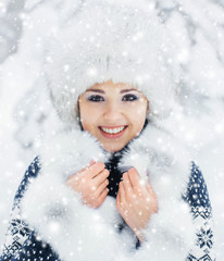 Portrait of a woman in a winter hat on a snow background