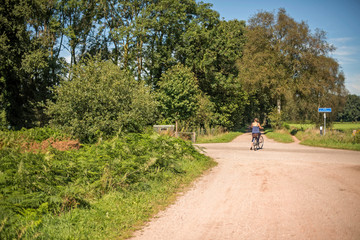 Tourist on bicycle standing on crossing in summer. Winterswijk.