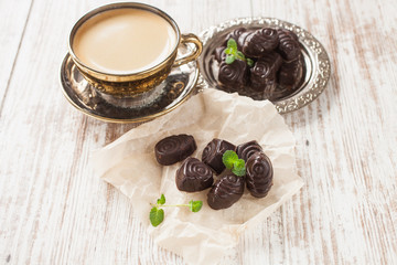 chocolates on paper and coffee on a table, selective focus