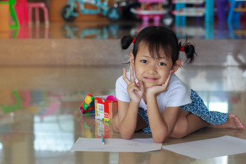 Portrait of a smiling little girl with happy to writing at home