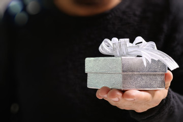 gift giving,man hand holding a gift box in a gesture of giving.b