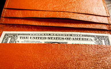 Orange wallet with male accessories on wooden background