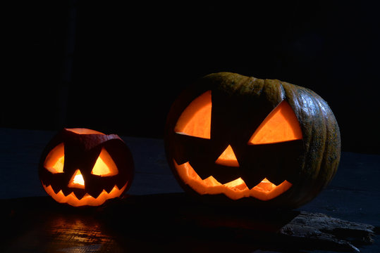 two halloween pumpkins jack faces in the dark with moonlight on
