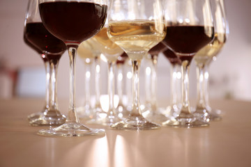 Glasses with red and white wine on table in restaurant