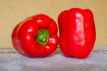 Two red bell peppers on table