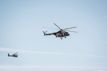 Two military helicopter on cloudy sky