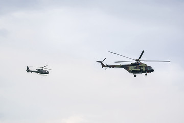 Two military helicopter on cloudy sky