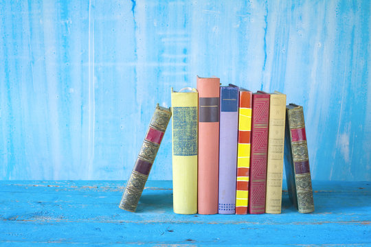 row of colorful old books, grungy background, good copy space