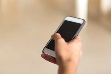 Man in an apartment writing a messege with mobile