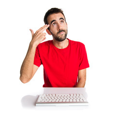 Computer technician working with his keyboard making suicide gesture