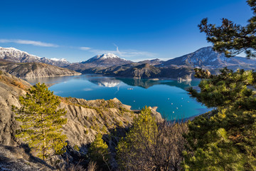Obraz premium Serre Poncon Lake from Le Rousset with Winter view on Saint Vincent Les Fort and Le Sauze du Lac. A peaceful area in Hautes Alpes, the Southern French Alps. France