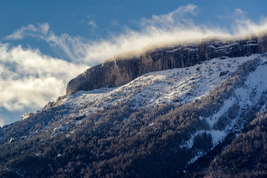 Ceuze mountain and cliff with  blowing snow in Winter. Hautes Alpes, Southern French Alps, France