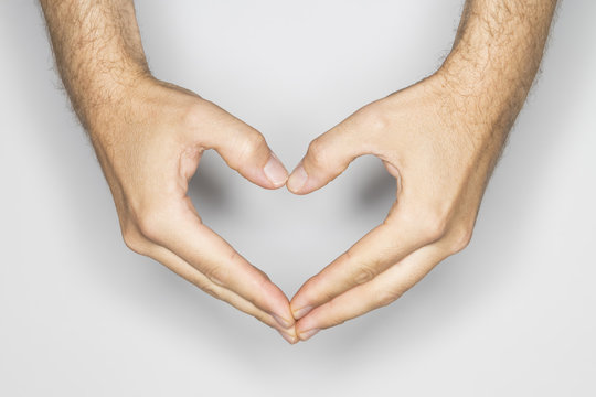 two caucasian hands in a gesture: heart for love