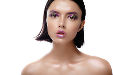 Beautiful woman model with shiny skin posing on a white background. The brunette with wet hair and a gentle colorful makeup.