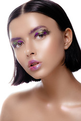 Beautiful woman model with shiny skin posing on a white background. The brunette with wet hair and a gentle colorful makeup.