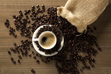 Coffee cup and coffee beans on wooden background. Top view.