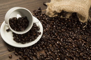 Coffee cup and coffee beans on wooden background. Top view.