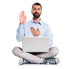 Man with laptop doing an oath