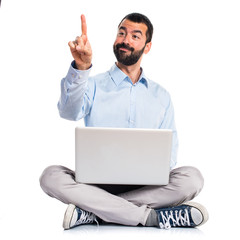 Man with laptop touching on transparent screen