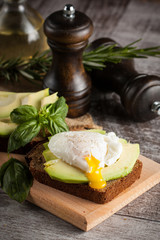 Healthy sandwich with avocado and poached eggs. Healthy food and diet concept.