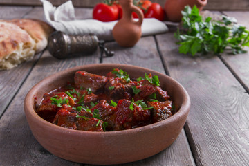 meat in tomato sauce beef roast in a clay bowl