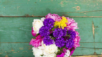 bouquet of colorful flowers on green wooden planks