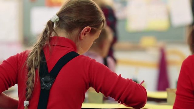The girl draws a picture paints in classroom