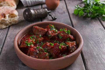 meat in tomato sauce beef roast in a clay bowl