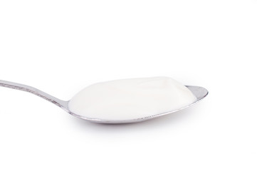 Sour cream in a spoon. On white, isolated background.