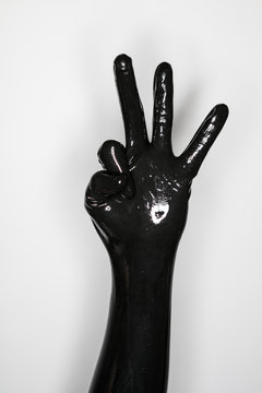 gesture of a hand wearing a black latex glove
