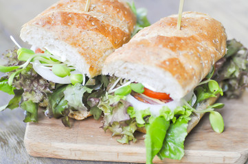baguette sandwich with ham, tomato,  and lettuce