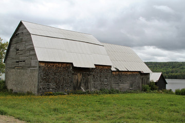 Obraz premium Old weathered barn with tin roof in rural farmland